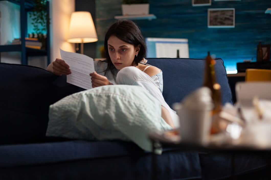 Woman reading at night, worried about frequent urination and kidney health.